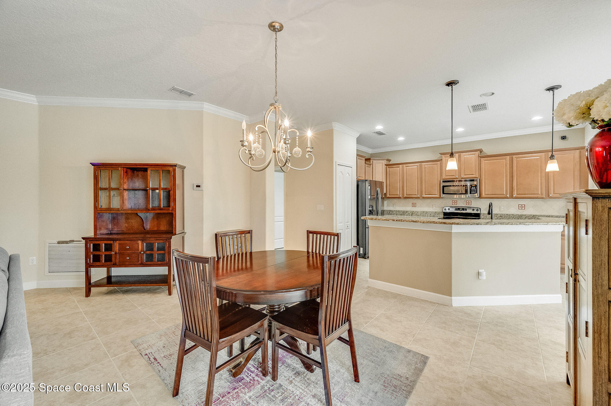 6531 Ingalls Street Melbourne, FL 32940 - Photo 2 of 46 a dining room filled chandelier and kitchen view