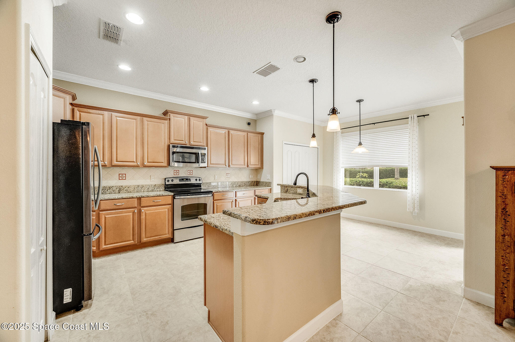 6531 Ingalls Street Melbourne, FL 32940 - Photo 22 of 46 a kitchen with stainless steel appliances granite countertop a refrigerator a sink dishwasher a stove and white cabinets with wooden floor