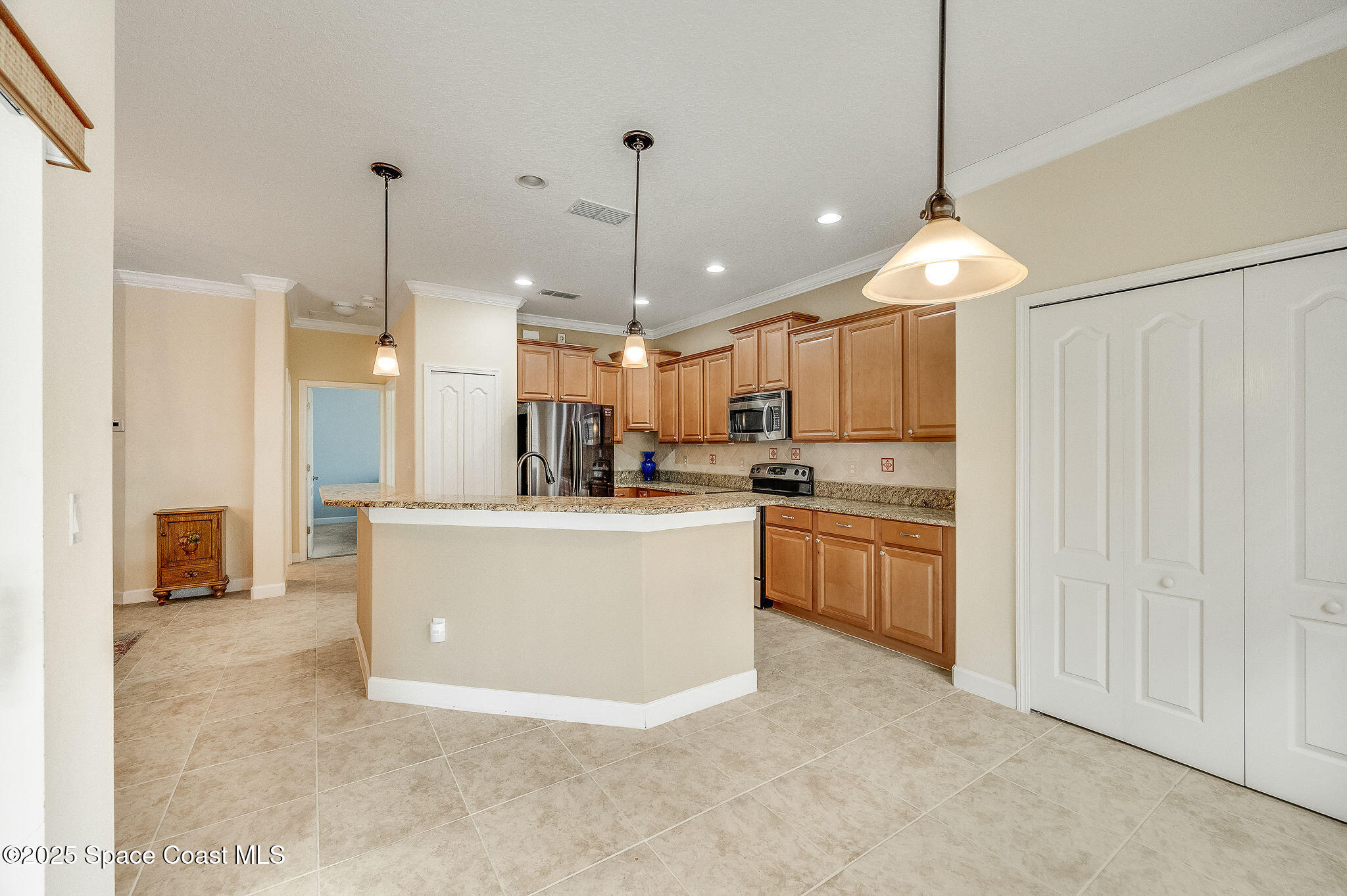 6531 Ingalls Street Melbourne, FL 32940 - Photo 23 of 46 a large kitchen with kitchen island a stove a sink a refrigerator and a view of living room