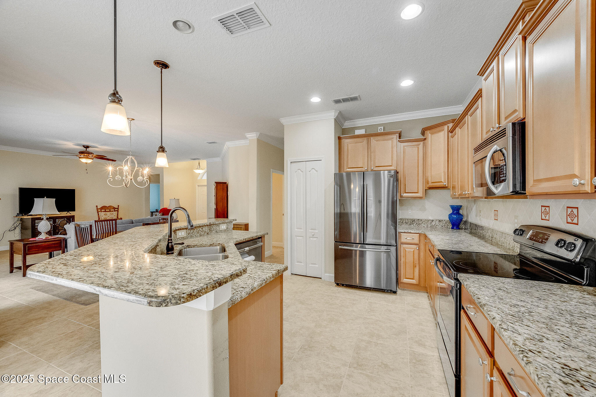 6531 Ingalls Street Melbourne, FL 32940 - Photo 26 of 46 a kitchen with stainless steel appliances granite countertop a sink stove and refrigerator