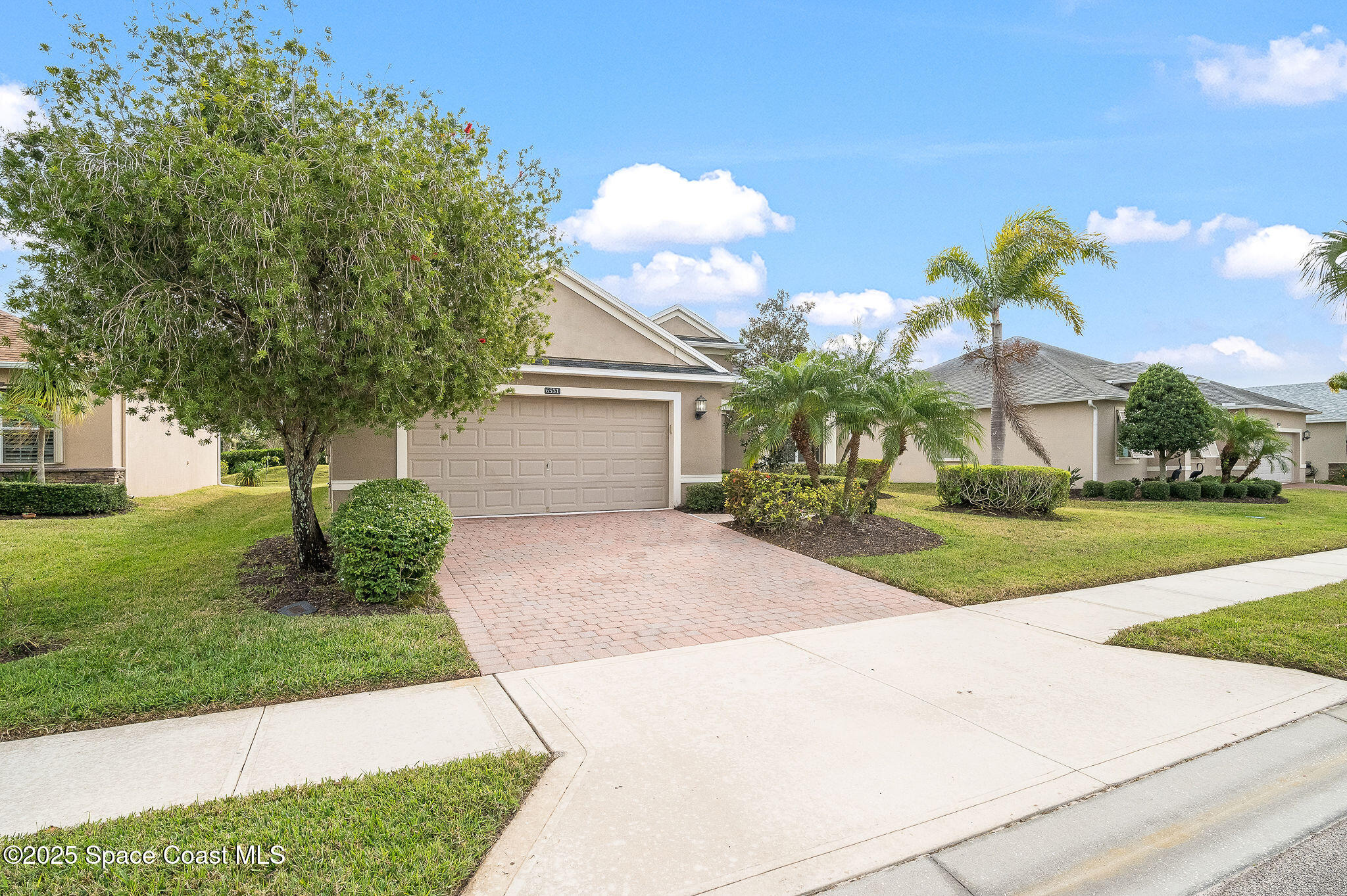 6531 Ingalls Street Melbourne, FL 32940 - Photo 3 of 46 a front view of a house with a yard and a garage