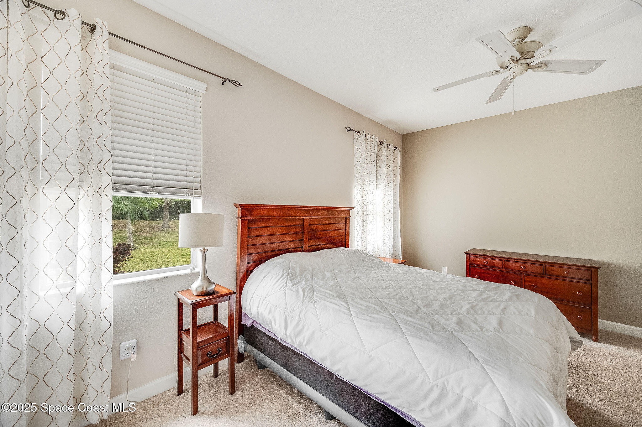 6531 Ingalls Street Melbourne, FL 32940 - Photo 40 of 46 a bedroom with a bed a chandelier and a window