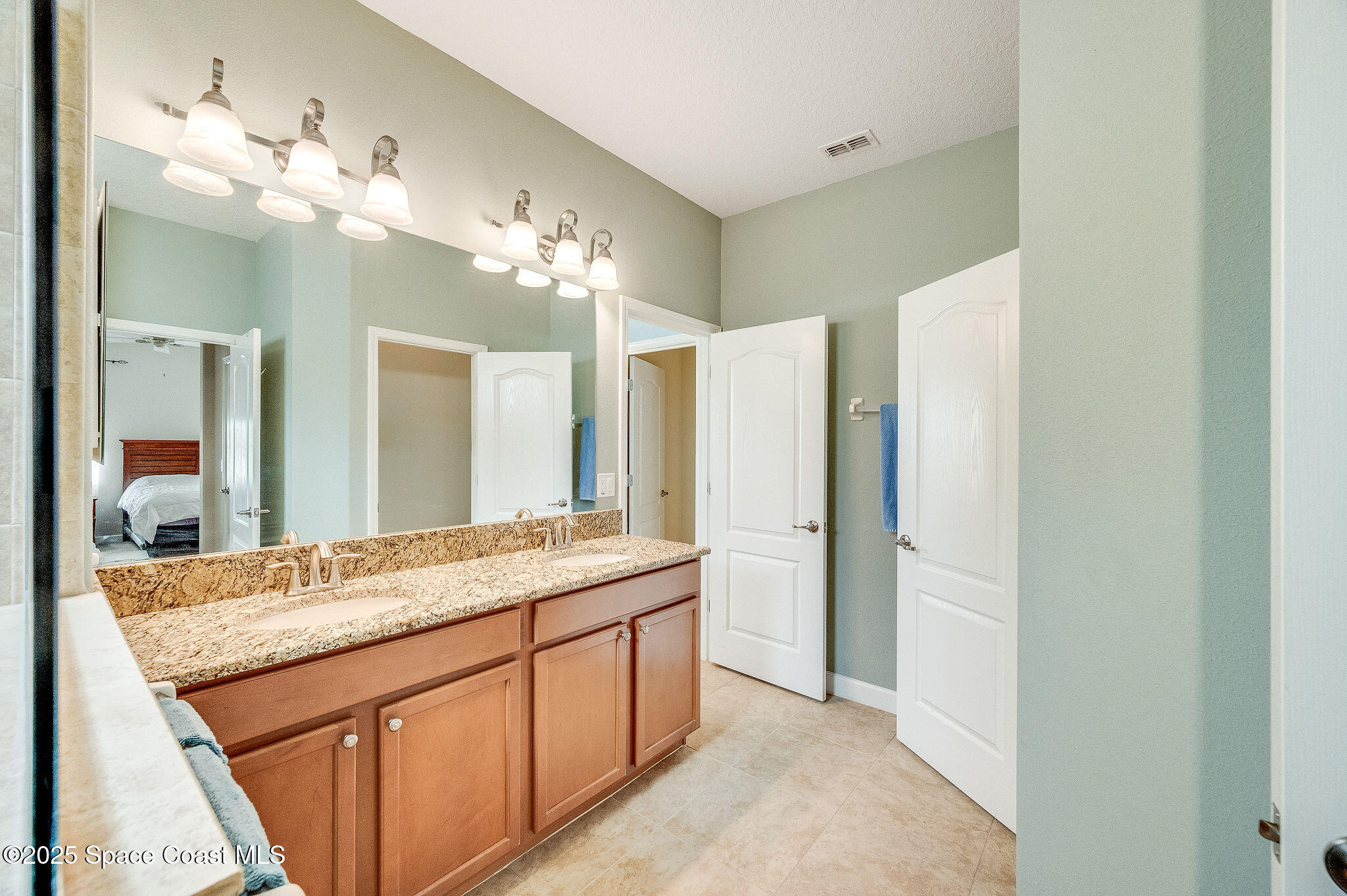 6531 Ingalls Street Melbourne, FL 32940 - Photo 43 of 46 a bathroom with a granite countertop sink a large mirror and a shower