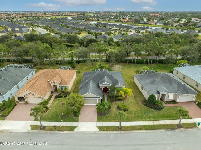 an aerial view of a house with a garden and lake view
