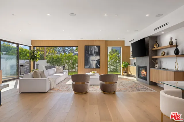 a living room with fireplace furniture and a large window