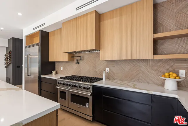a kitchen with stainless steel appliances a stove a microwave a sink and cabinets