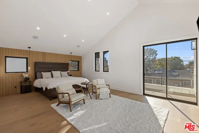 a spacious bedroom with a bed and glass door