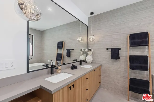 a bathroom with a double vanity sink a mirror and glass door