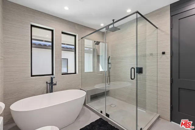 a white bath tub sitting next to a shower