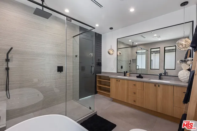 a bathroom with a double vanity sink toilet mirror and shower