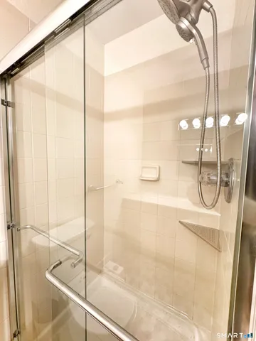 a bathroom with a glass shower door and a shower