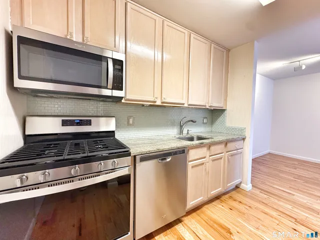 a kitchen with stainless steel appliances granite countertop a stove and a microwave