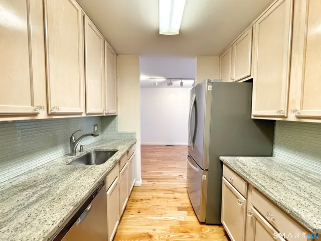 a kitchen with granite countertop a sink and a refrigerator