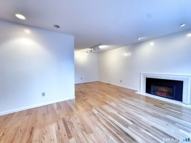 an empty room with wooden floor and a fireplace