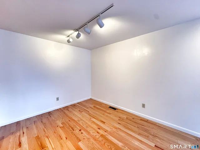 en empty room with wooden floor and fan