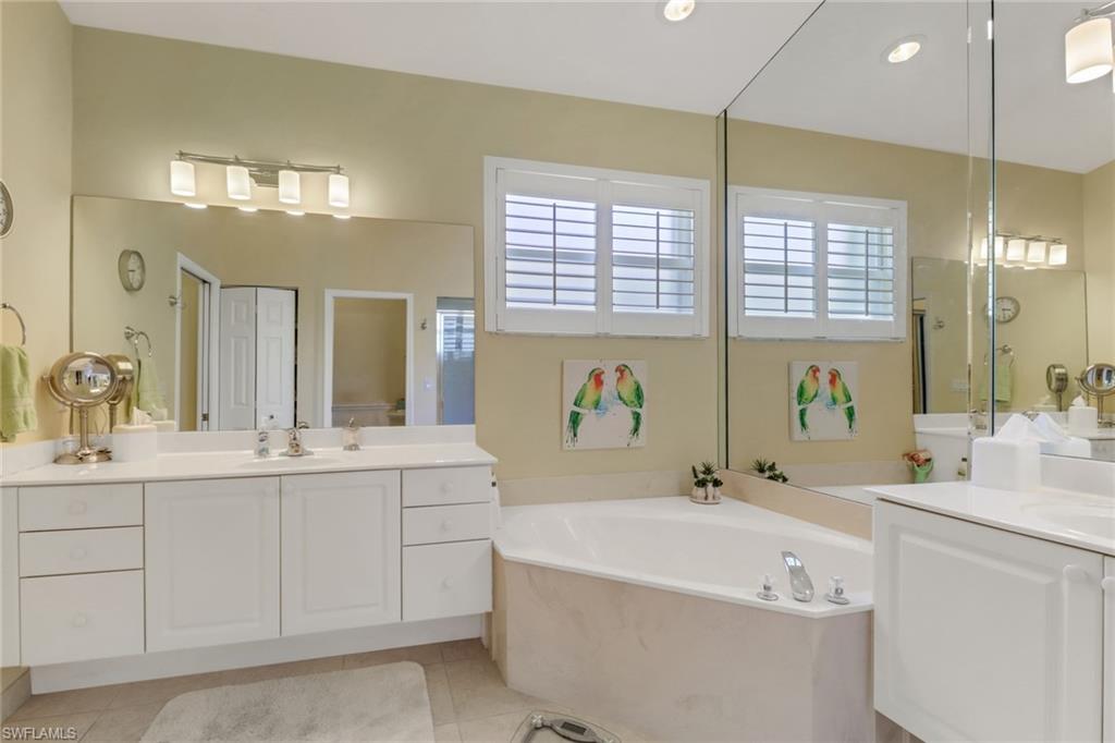 9001 Springview Loop Estero, FL 33928 - Photo 18 of 50 a bathroom with a tub a sink and mirror