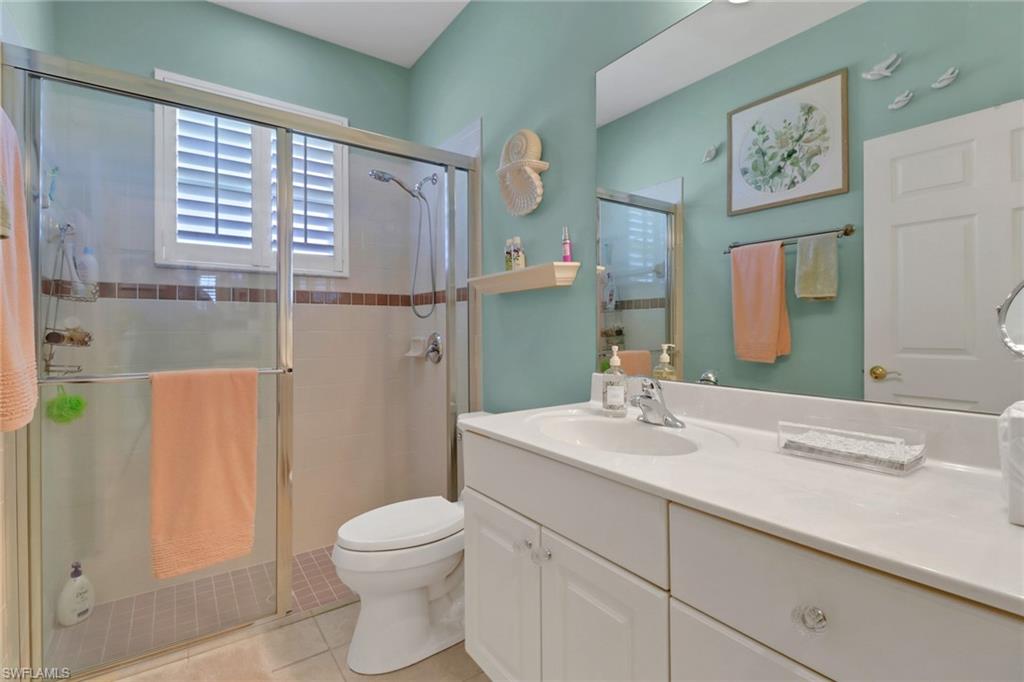 9001 Springview Loop Estero, FL 33928 - Photo 20 of 50 a bathroom with a sink a toilet and a large mirror