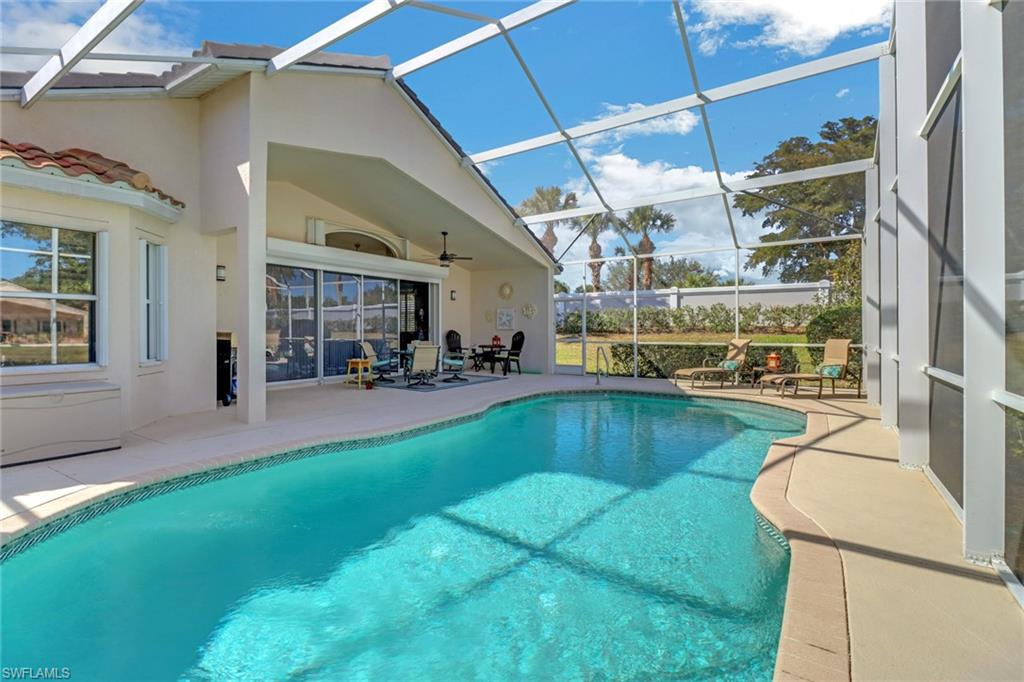 9001 Springview Loop Estero, FL 33928 - Photo 26 of 50 a swimming pool with outdoor seating and yard
