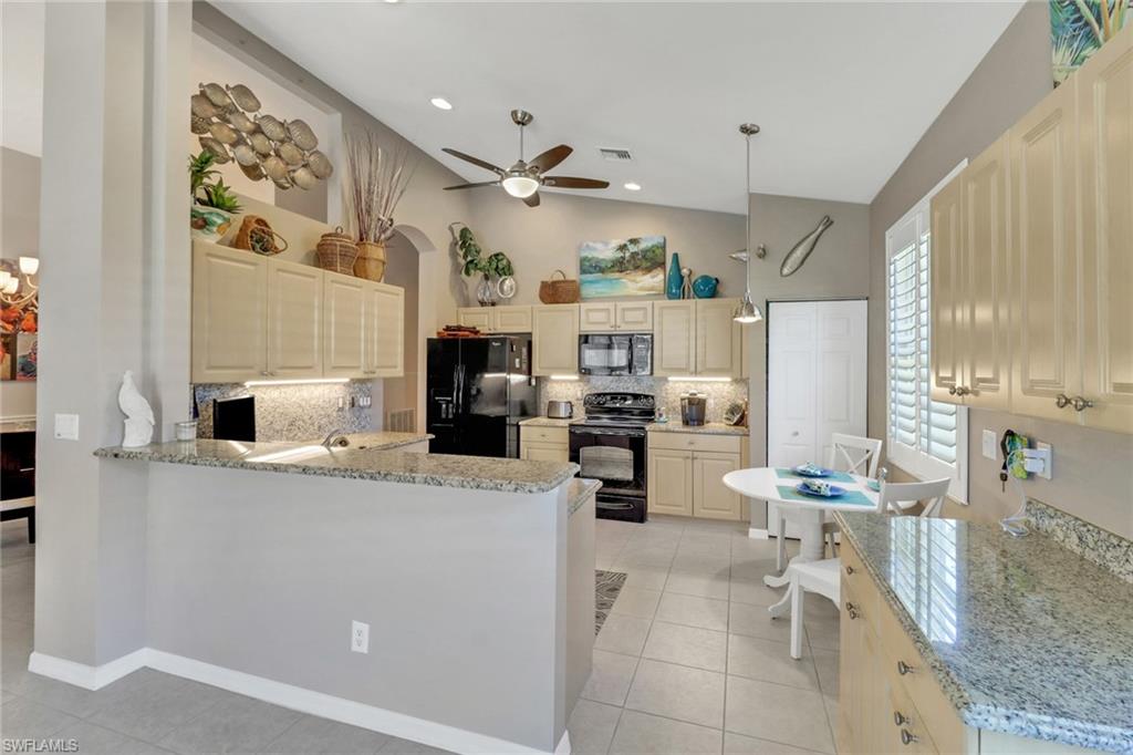 9001 Springview Loop Estero, FL 33928 - Photo 8 of 50 a kitchen with stainless steel appliances kitchen island granite countertop a sink and cabinets