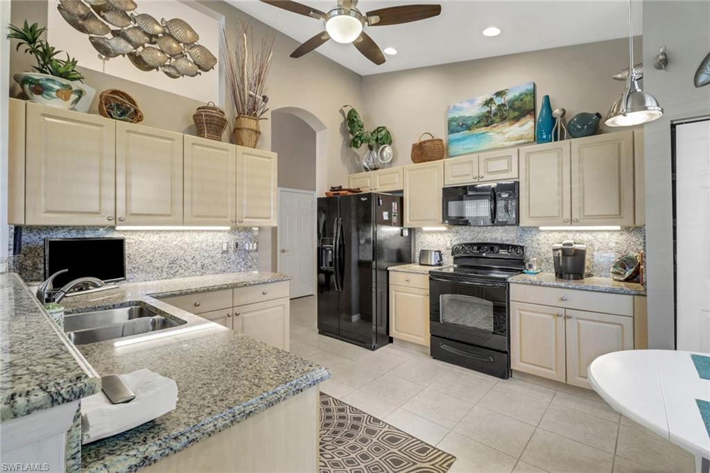 9001 Springview Loop Estero, FL 33928 - Photo 9 of 50 a kitchen with stainless steel appliances granite countertop a sink stove and refrigerator