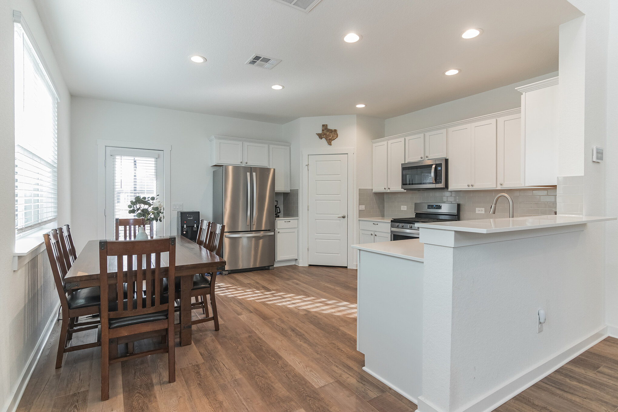 116 Century Plant Road Leander, TX 78641 - Photo 14 of 30 Gleaming hardwood floors and recessed lighting anchor this open-concept kitchen and dining space.