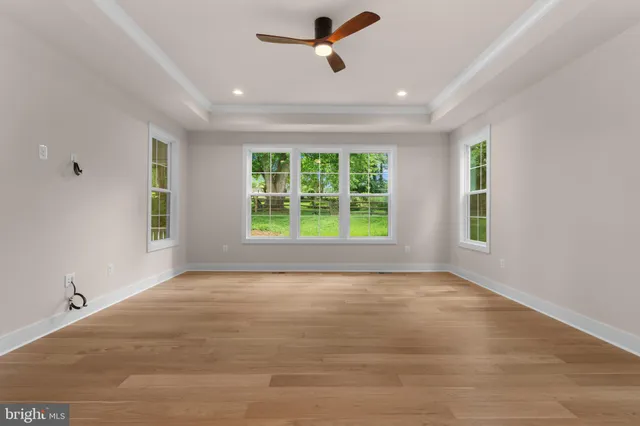 a spacious bathroom with a granite countertop sink a toilet a mirror and shower