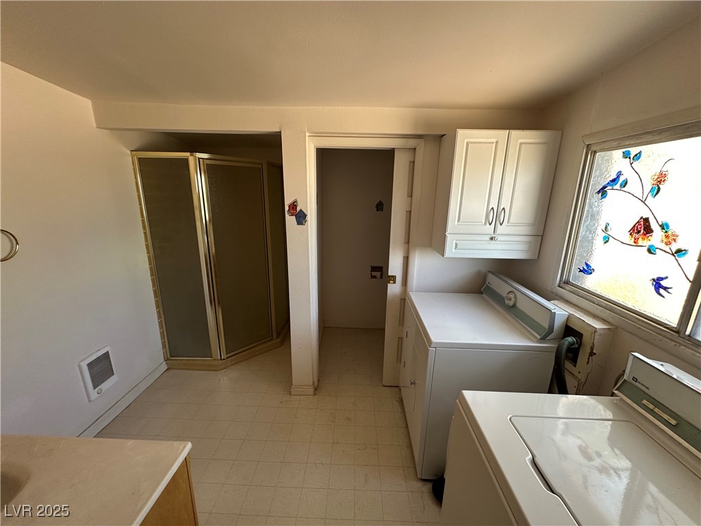 336 Hoffman Street Pioche, NV 89043 - Photo 16 of 36 Laundry room featuring washing machine and dryer, cabinet space, and heating unit