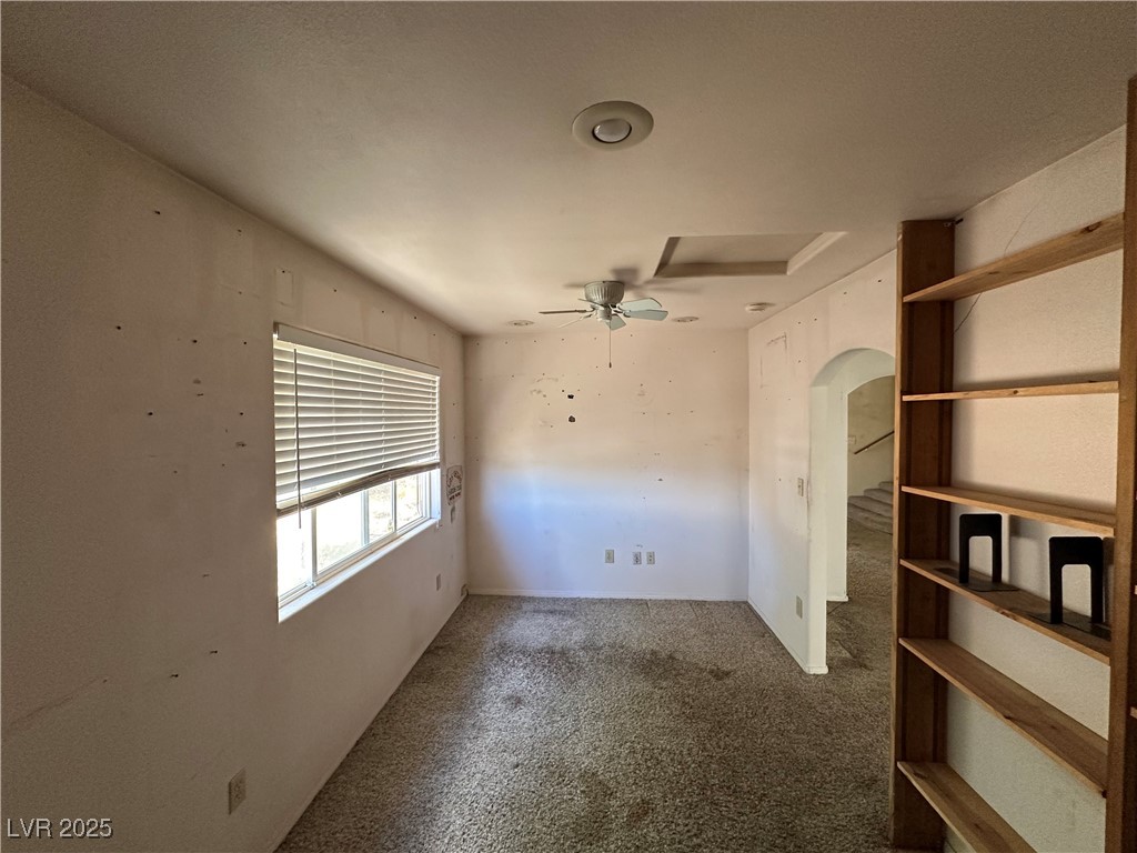 336 Hoffman Street Pioche, NV 89043 - Photo 25 of 36 Empty room with carpet floors, arched walkways, and ceiling fan