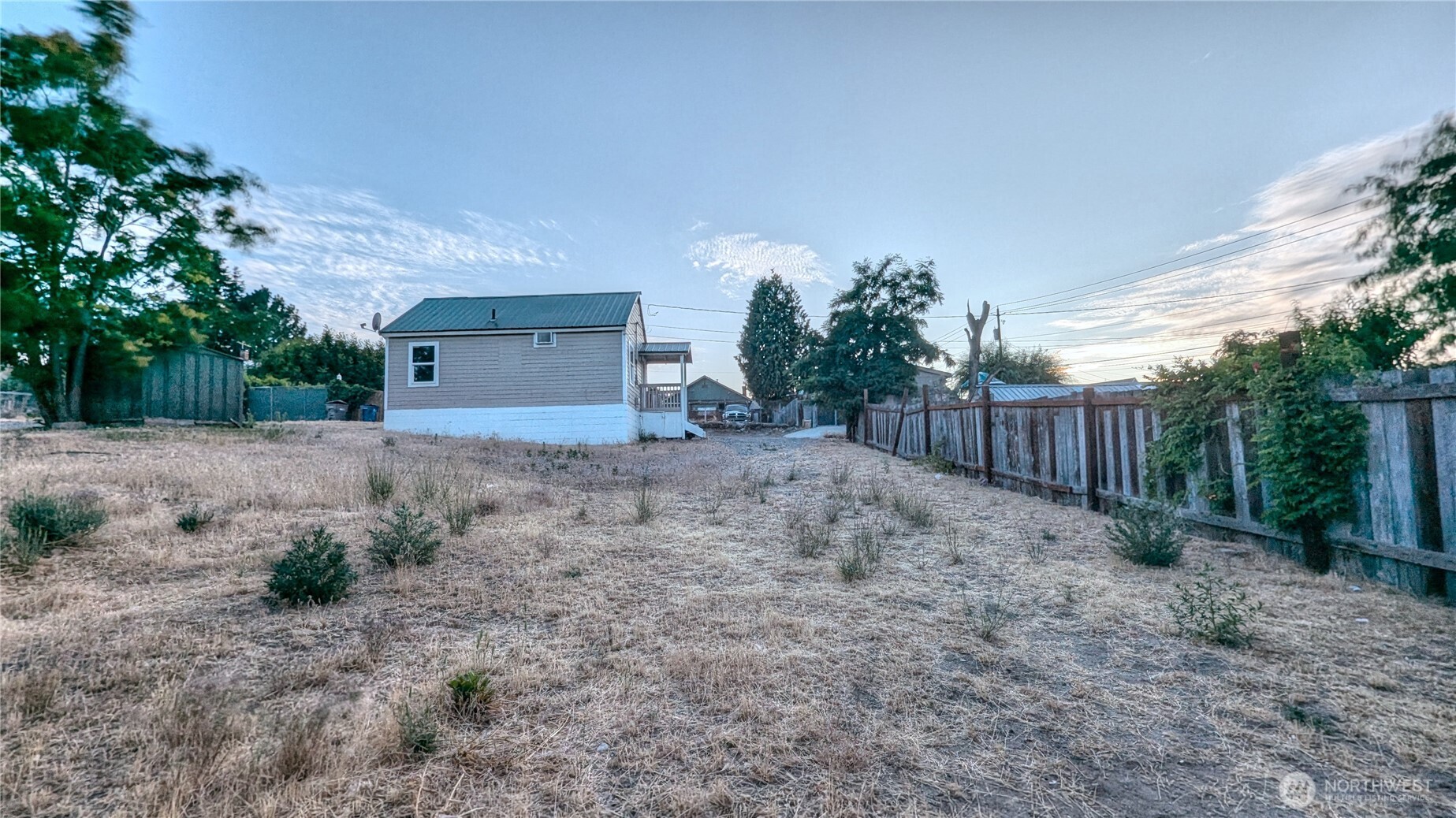 706 Methow Street Wenatchee, WA 98801 - Photo 4 of 7 a view of a backyard with large trees and wooden fence