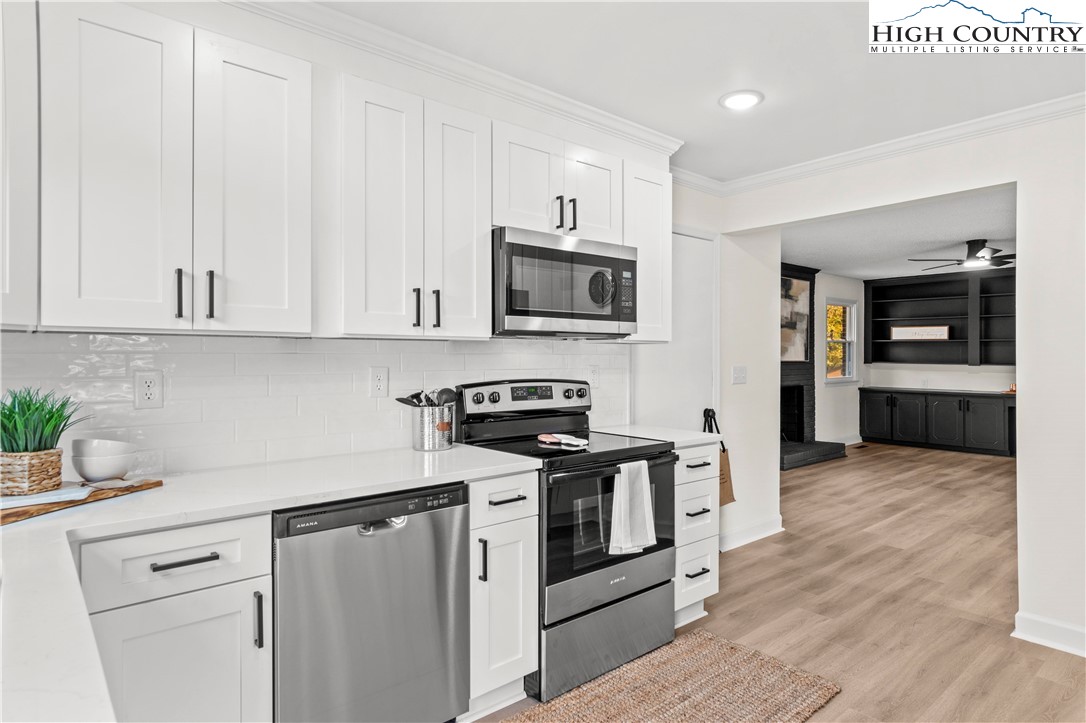 765 Laverton Lane Rural Hall, NC 27045 - Photo 18 of 41 a kitchen with stainless steel appliances granite countertop a stove a sink and a microwave