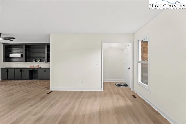 a view of an empty room with a fireplace and a window