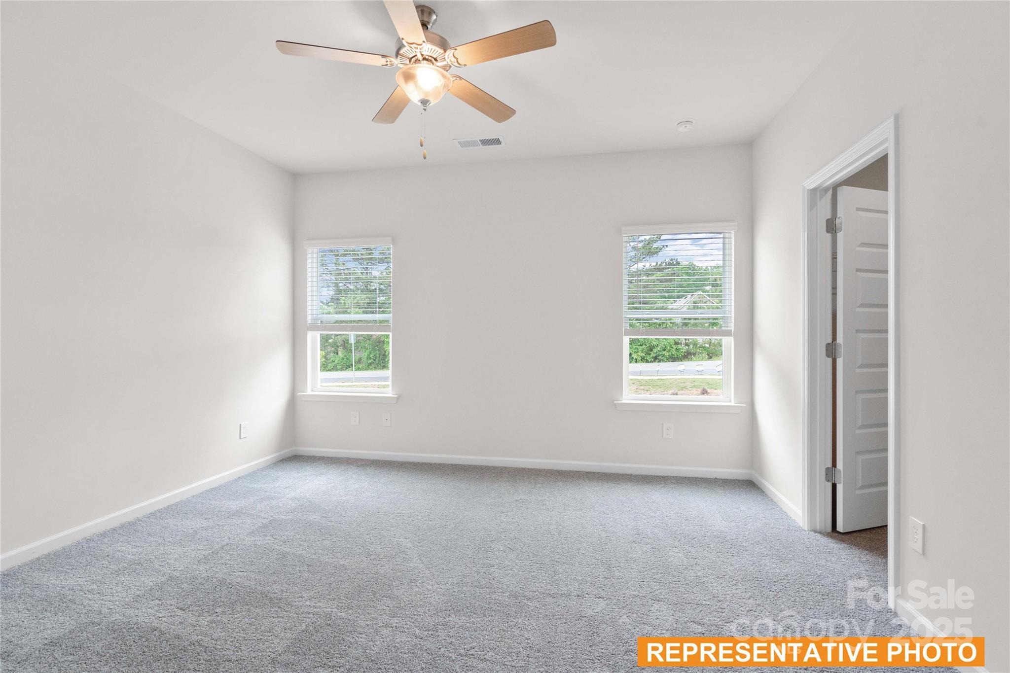6013 Jasmine Br Road Charlotte, NC 28216 - Photo 12 of 26 an empty room with windows and fan