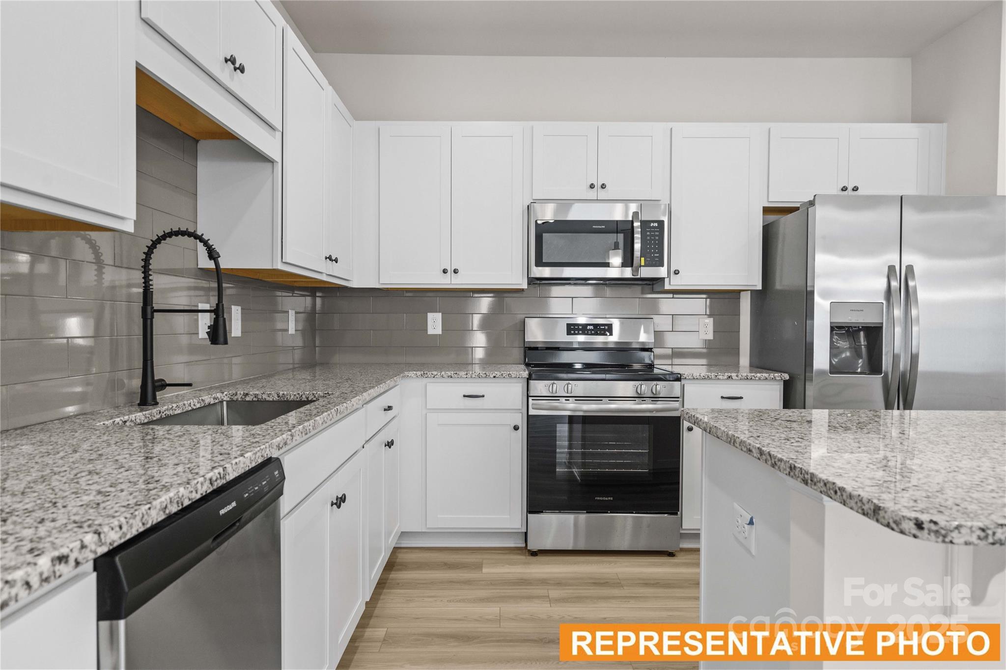 6013 Jasmine Br Road Charlotte, NC 28216 - Photo 4 of 26 a kitchen with stainless steel appliances granite countertop a sink stove microwave and refrigerator