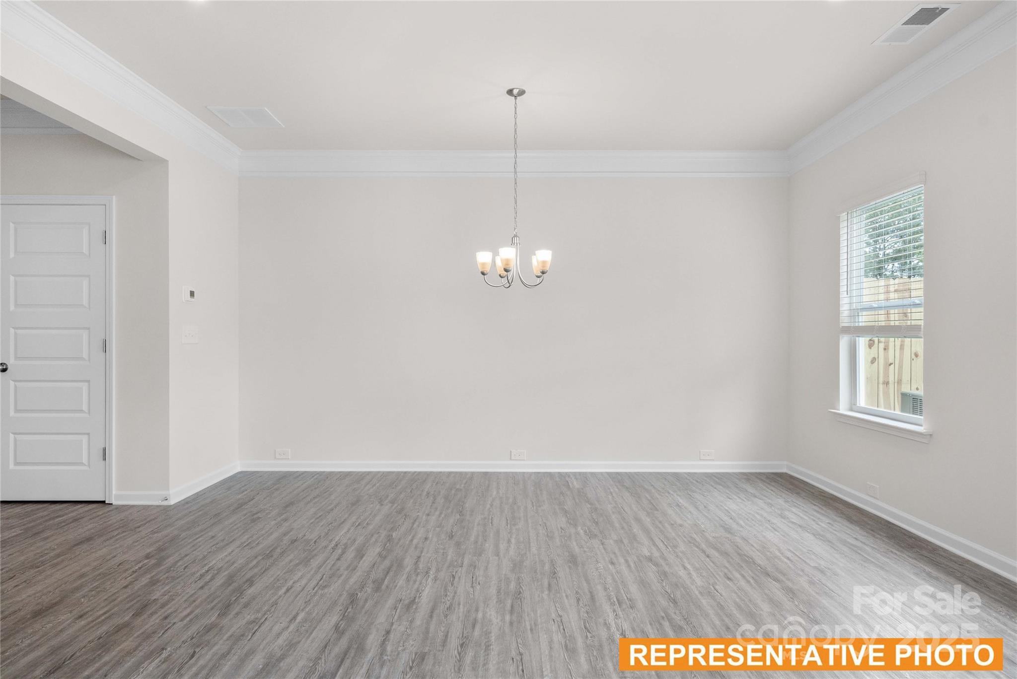 6013 Jasmine Br Road Charlotte, NC 28216 - Photo 9 of 26 an empty room with wooden floor and windows