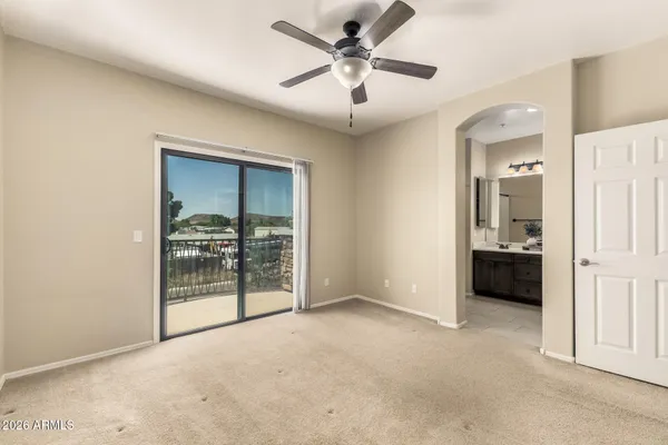 an empty room with closet and a ceiling fan