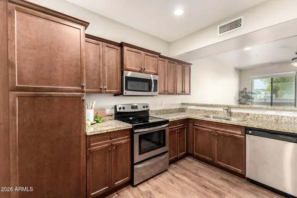 a kitchen with stainless steel appliances granite countertop a refrigerator and a sink