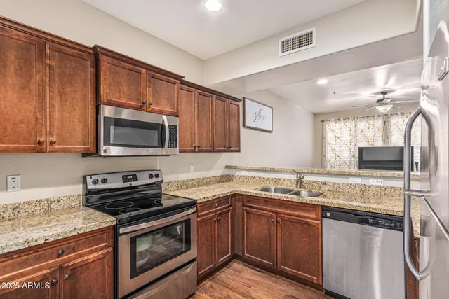 a kitchen with stainless steel appliances granite countertop a sink stove and microwave