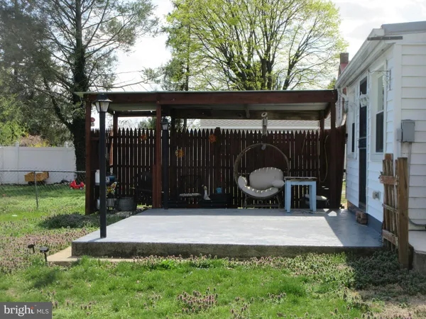 a view of a chair and table in backyard of the house