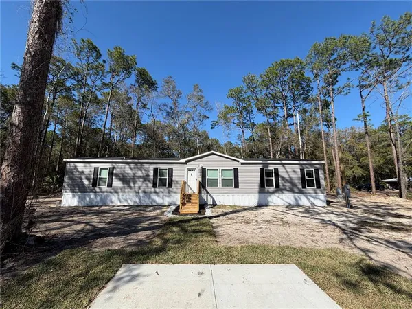 a view of a house with a small yard and sitting area