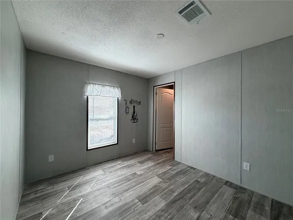 an empty room with windows and closet