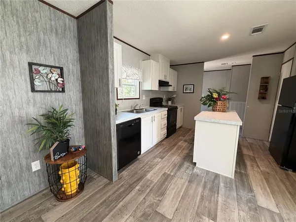 a kitchen with sink refrigerator and microwave