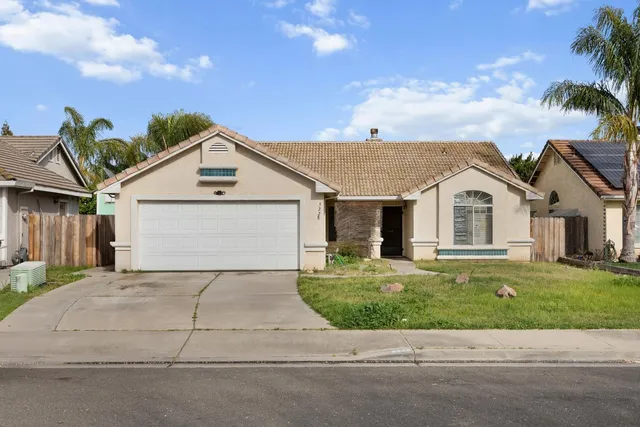 a view of a house with a yard and potted plants