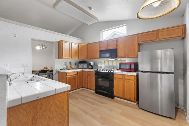 a kitchen with a refrigerator a stove a sink and a cabinets