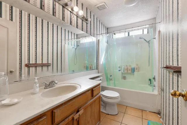 a bathroom with a granite countertop sink toilet and shower