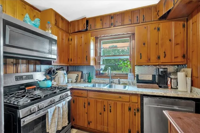 a kitchen with stainless steel appliances granite countertop a stove sink and cabinets