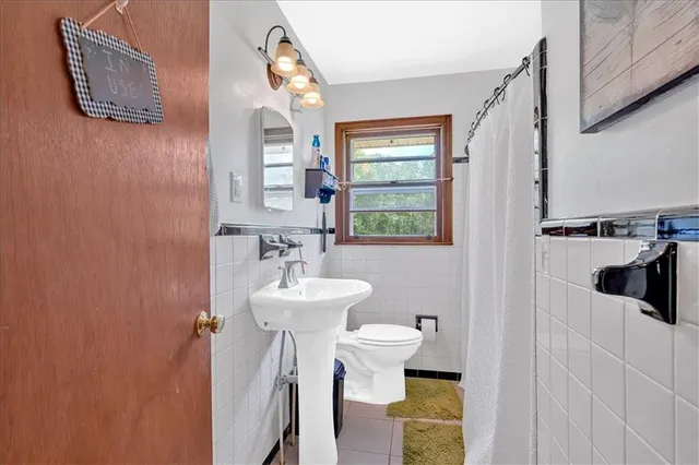 a bathroom with a sink a toilet and mirror