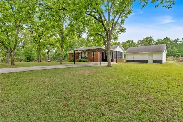 a view of a house with yard and sitting area