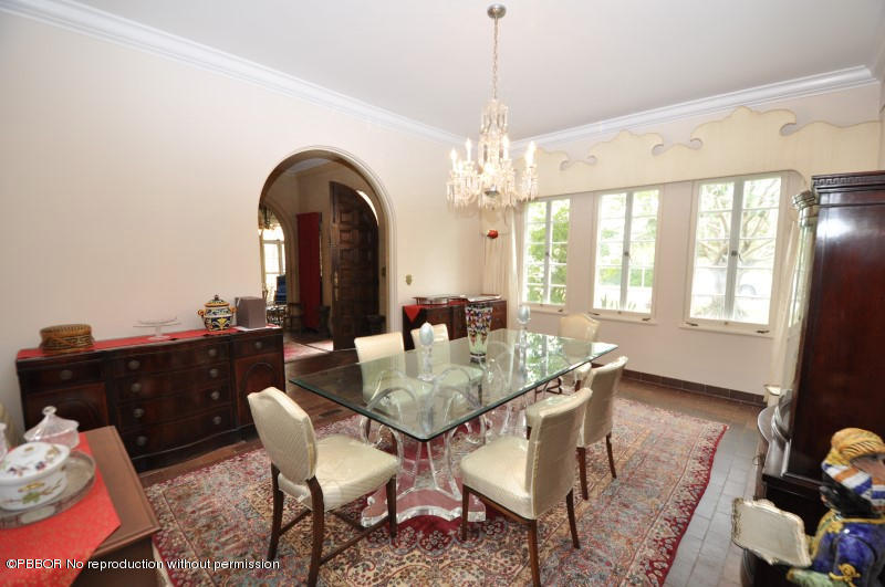 245 Valencia Road West Palm Beach, FL 33401 - Photo 12 of 19 a dining room with wooden floor a chandelier a wooden table and chairs