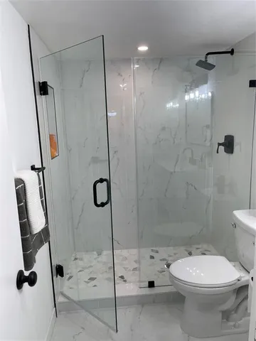 a bathroom with a toilet and a shower