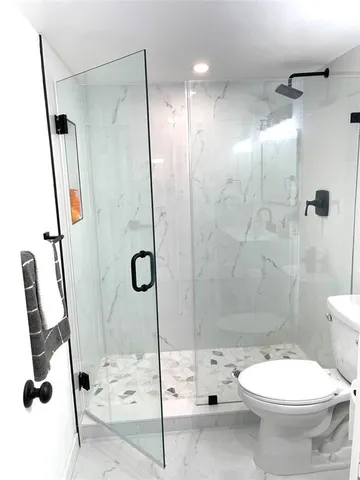 a bathroom with a toilet and a shower